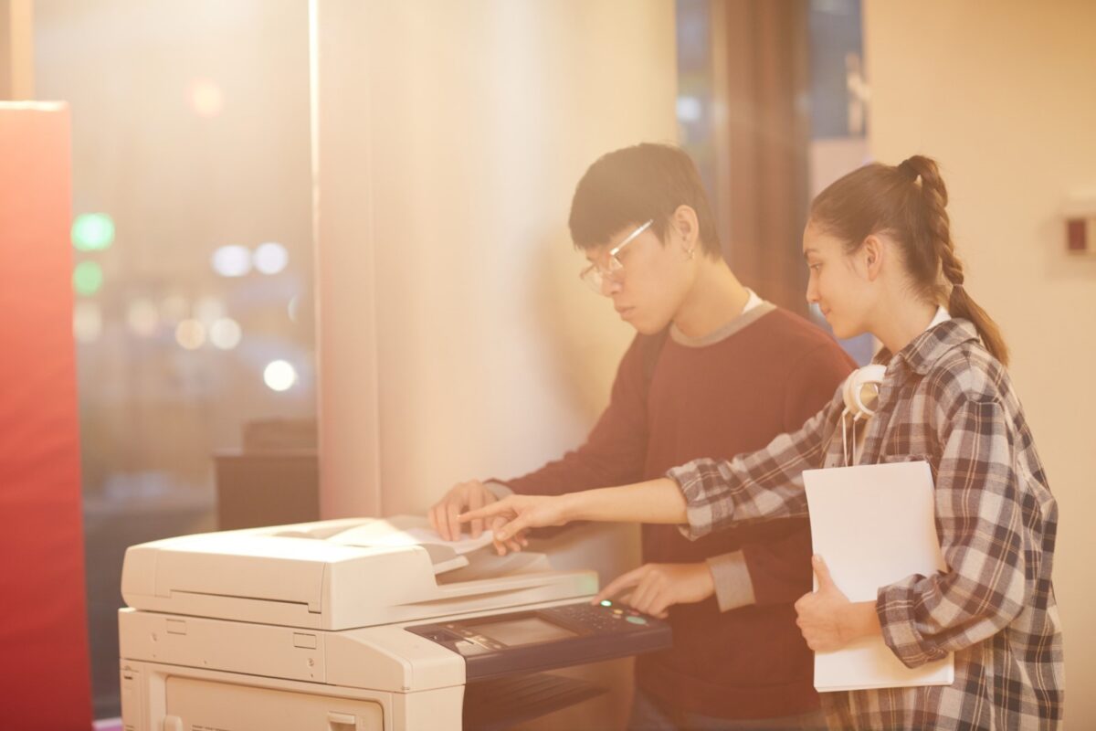 asian man and white woman using a photocopier