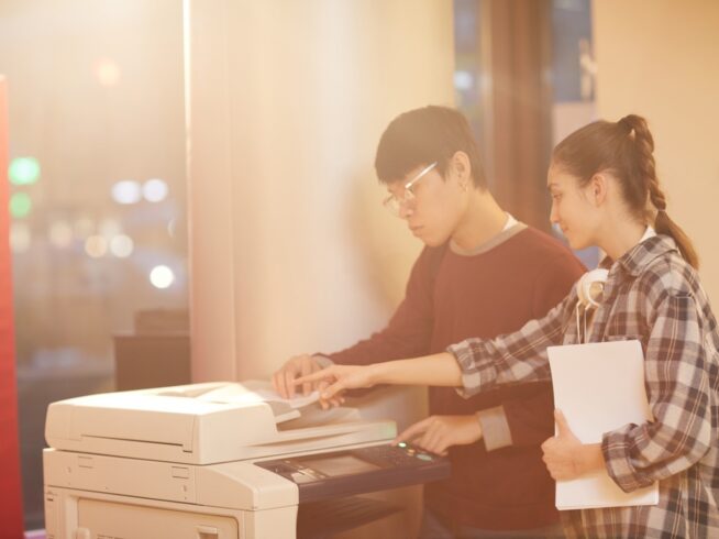 asian man and white woman using a photocopier